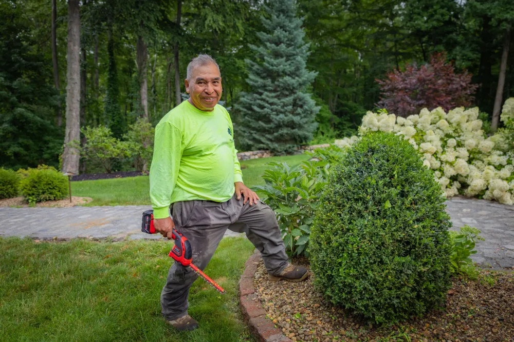 A Downer Brothers crew member with his trimmer by a finished bed