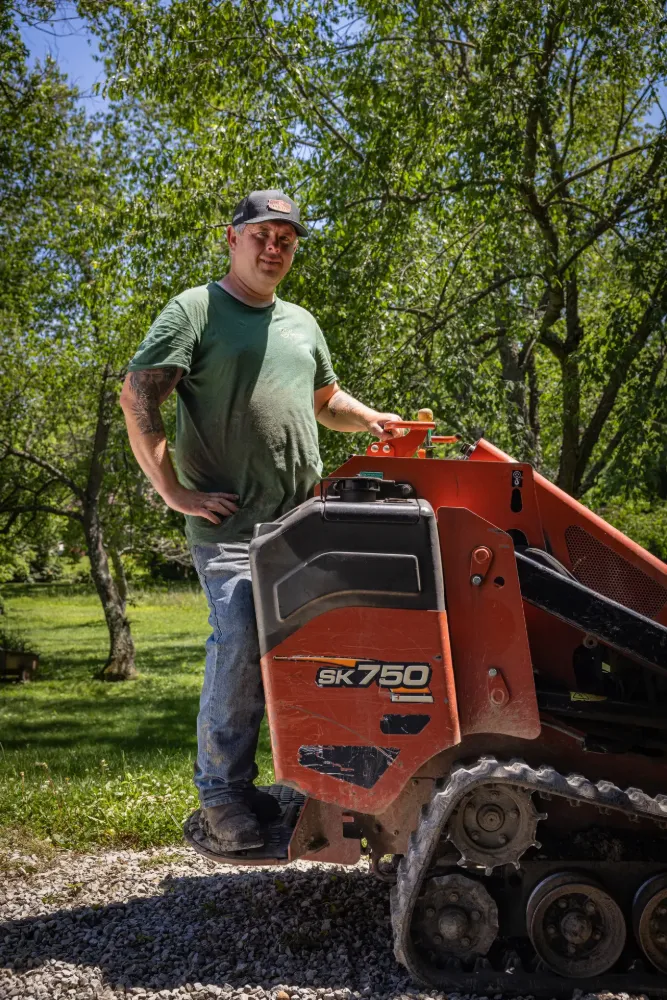 A crew lead standing with his compact track loader